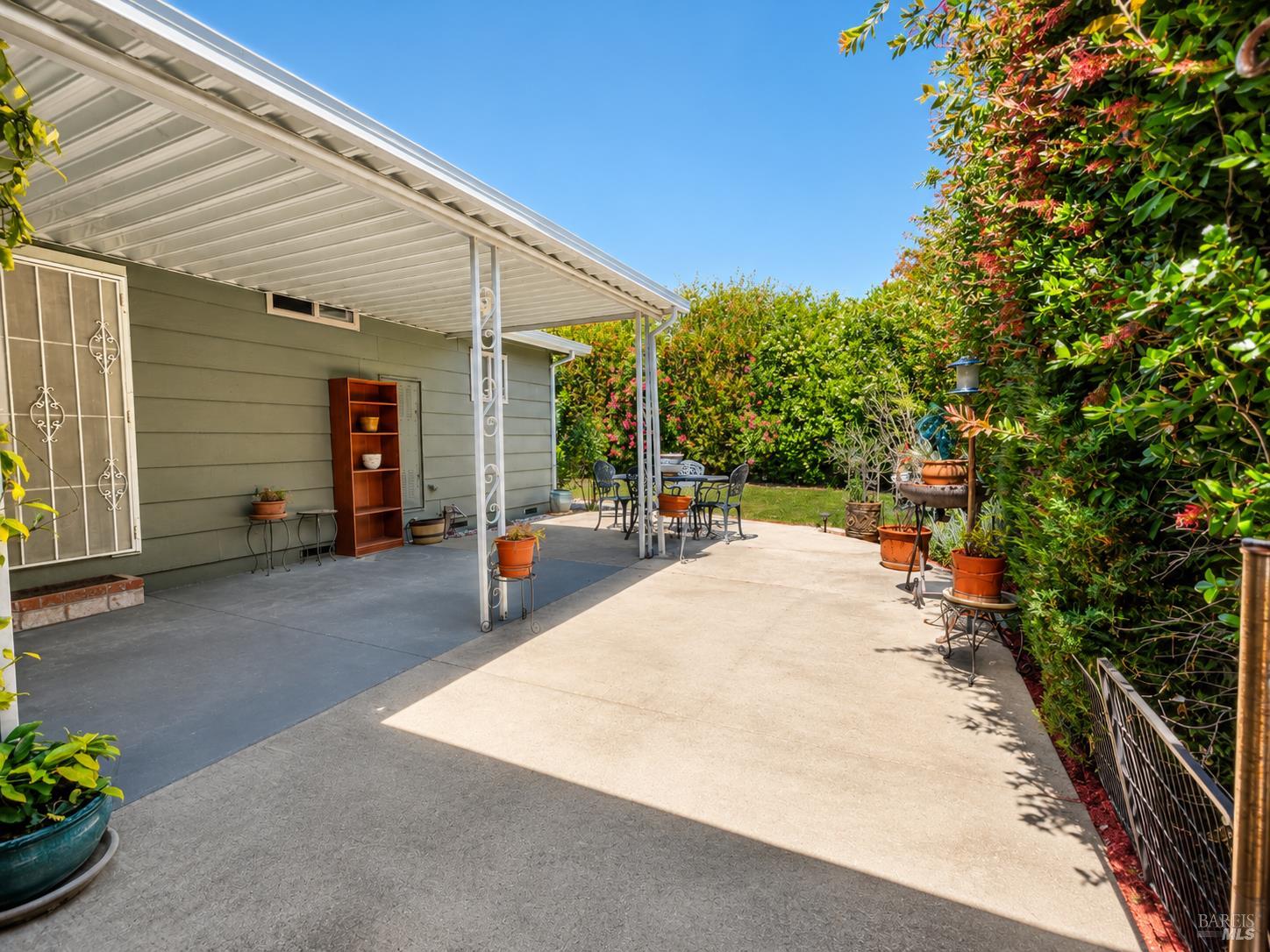 1945 Piner Road, Unit 16 Santa Rosa, CA 95403 - Photo 16 of 18 a view of a patio with table and chairs with wooden fence and plants