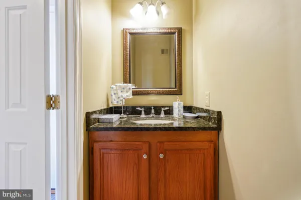 a bathroom with a granite countertop sink and a mirror