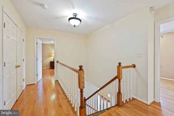 a view of a hallway with wooden floor and staircase