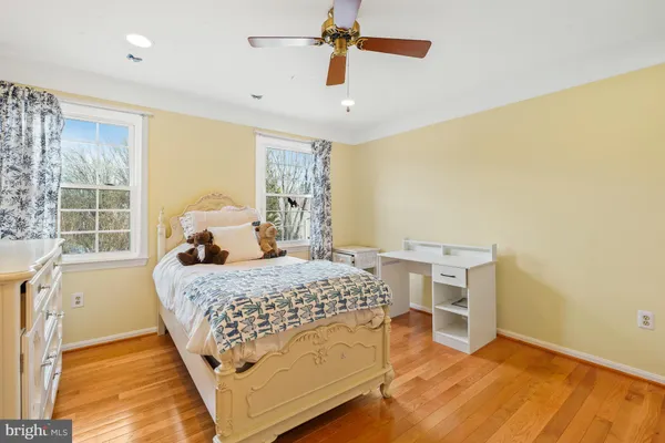 a bedroom with a bed wooden floor and window