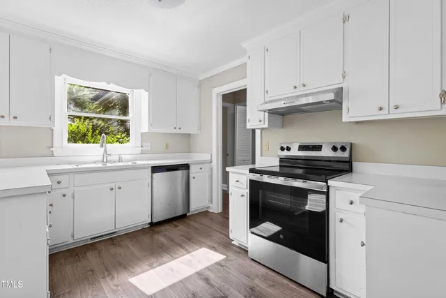 a kitchen with a sink window and cabinets