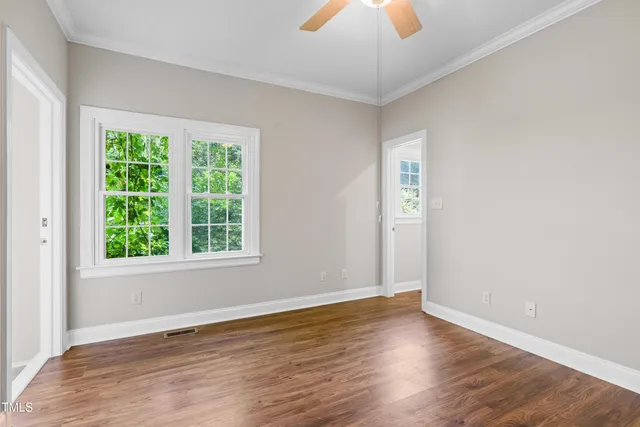 a view of an empty room with wooden floor