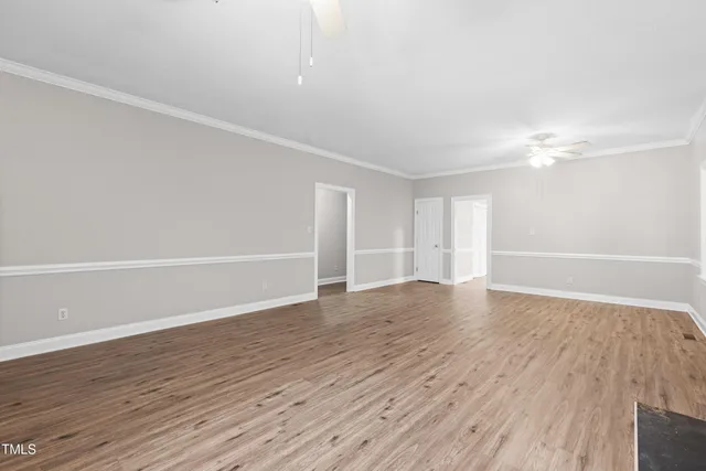 a kitchen with granite countertop wooden floors white cabinets and window