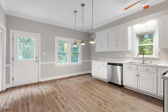 a kitchen with granite countertop a stove a sink and a refrigerator