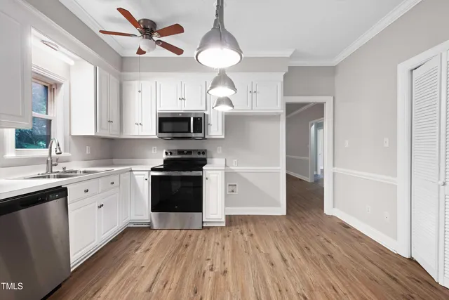 an empty room with windows and ceiling fan