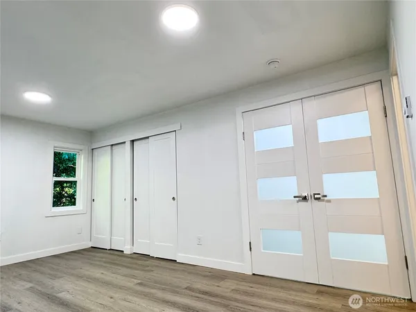 an empty room with wooden floor and window