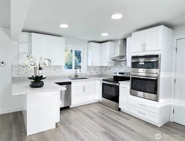 a kitchen with a sink white cabinets and white appliances