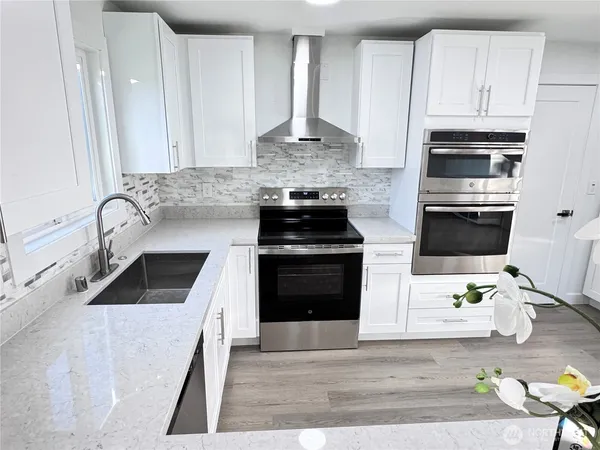 a kitchen with granite countertop a stove sink and cabinets
