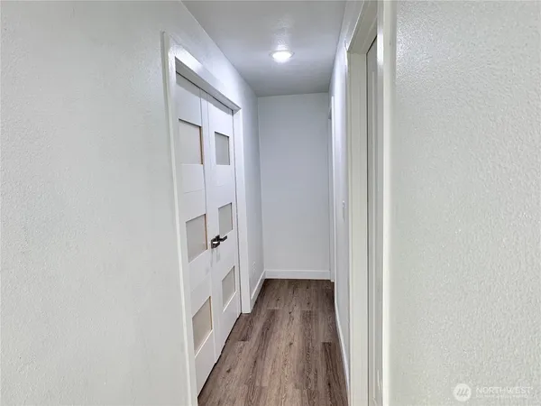 a view of a hallway with wooden floor and staircase