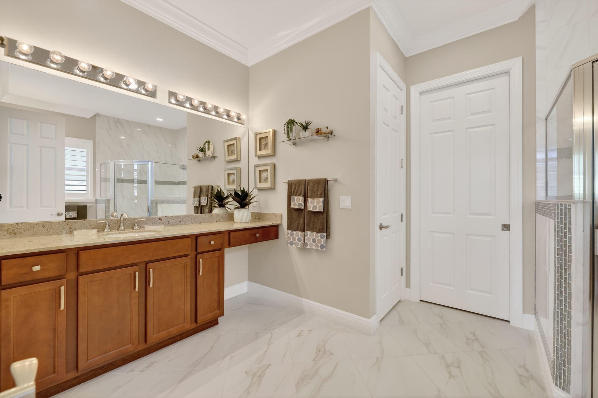 10619 Southwest Capraia Way Port St. Lucie, FL 34986 - Photo 23 of 90 a large bathroom with a large mirror vanity and shower
