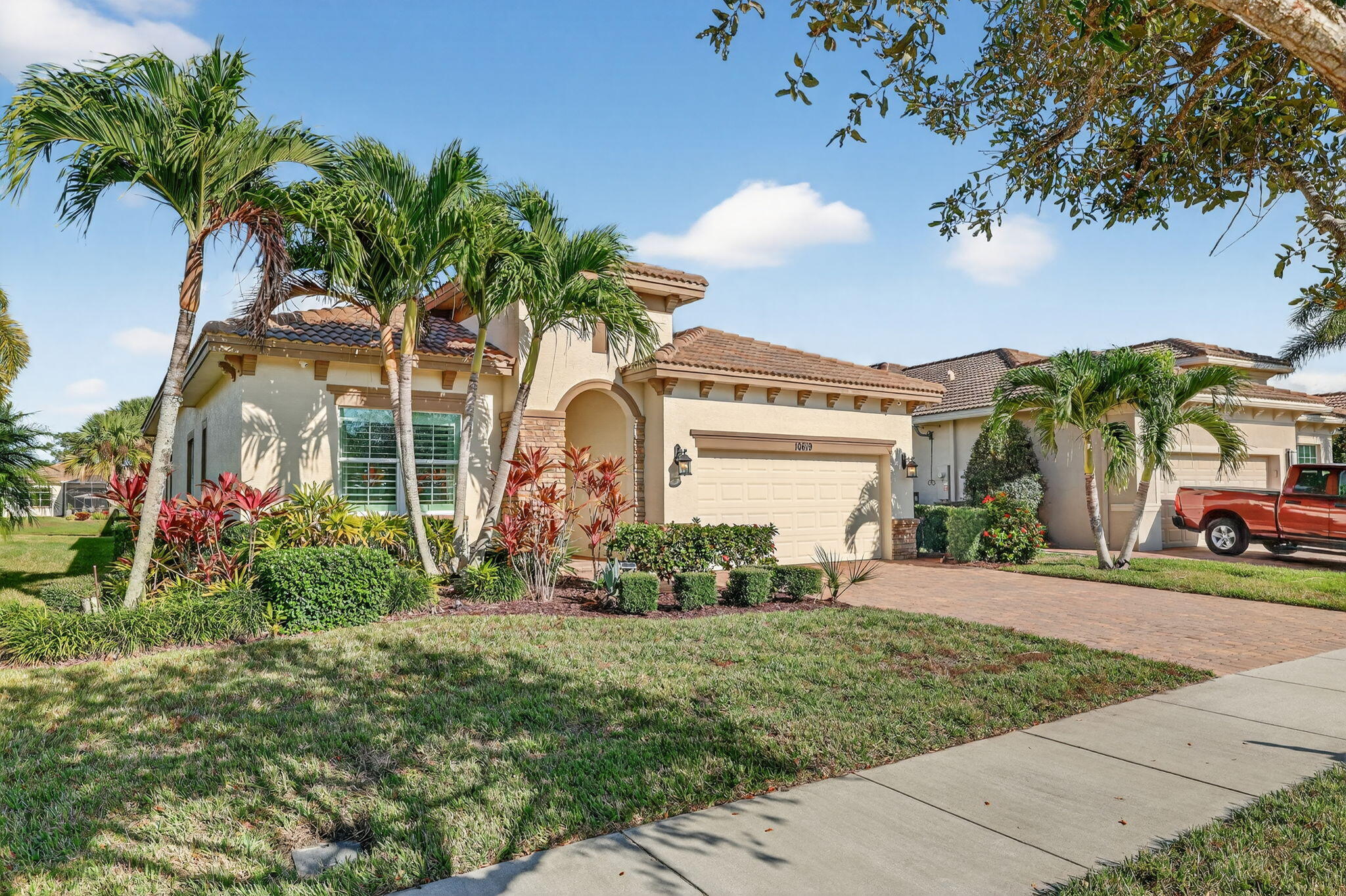 10619 Southwest Capraia Way Port St. Lucie, FL 34986 - Photo 3 of 90 a view of a white house with a big yard and potted plants