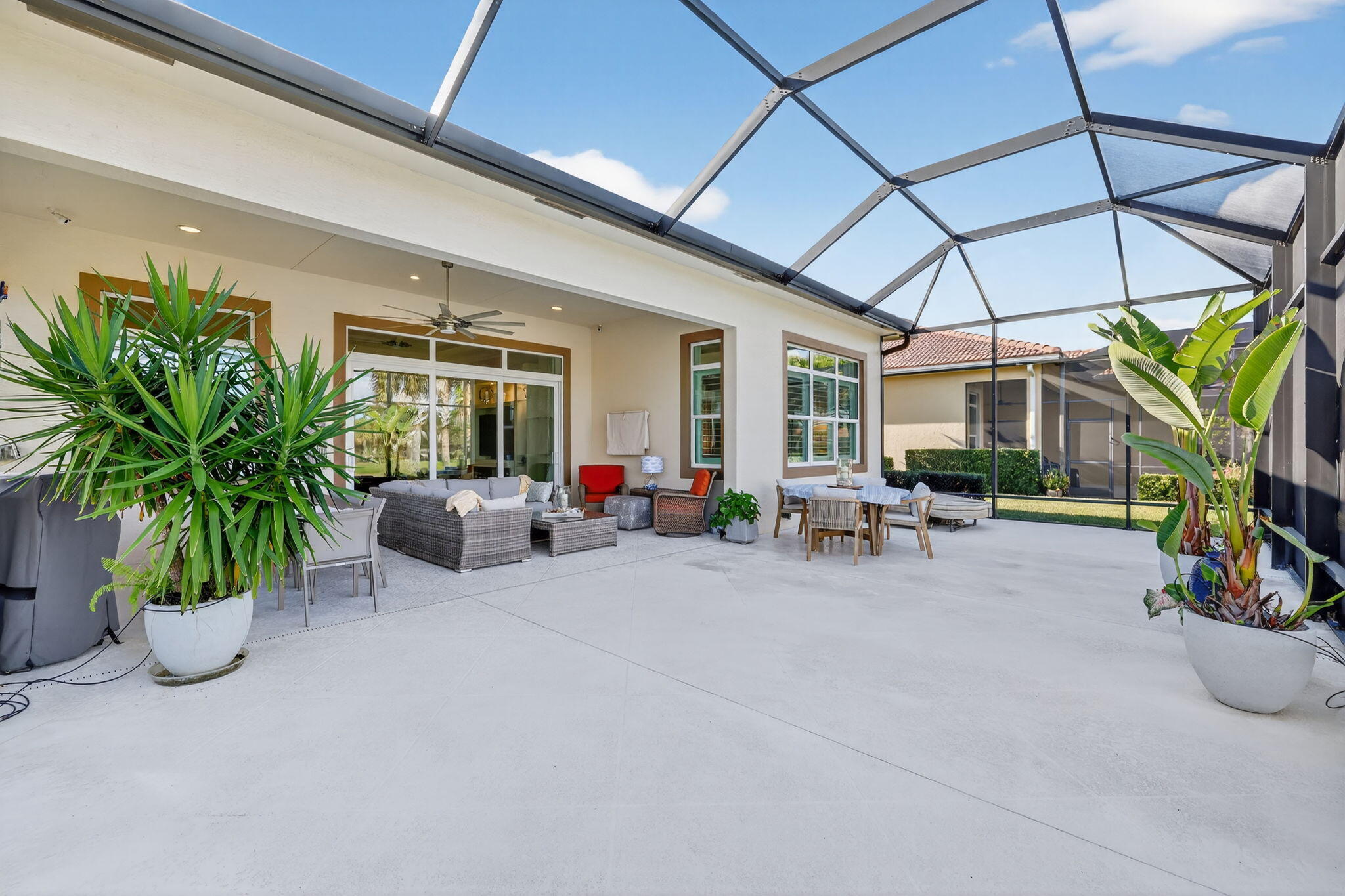 10619 Southwest Capraia Way Port St. Lucie, FL 34986 - Photo 38 of 90 a view of a patio with plants and chairs under an umbrella