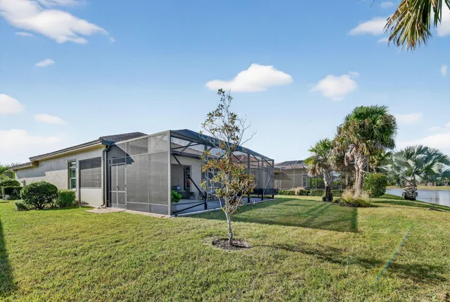 a swimming pool with outdoor seating and lots of trees in the background
