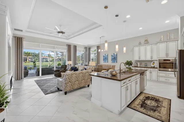 a kitchen with granite countertop white cabinets stainless steel appliances and a sink