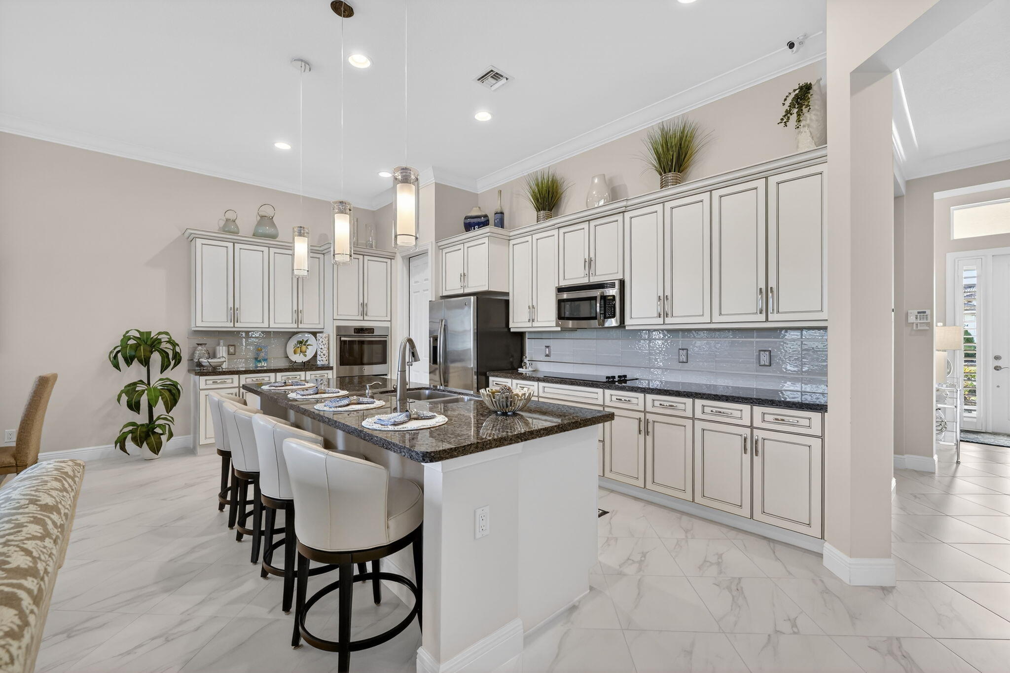 10619 Southwest Capraia Way Port St. Lucie, FL 34986 - Photo 9 of 90 a kitchen with stainless steel appliances kitchen island granite countertop a sink and cabinets