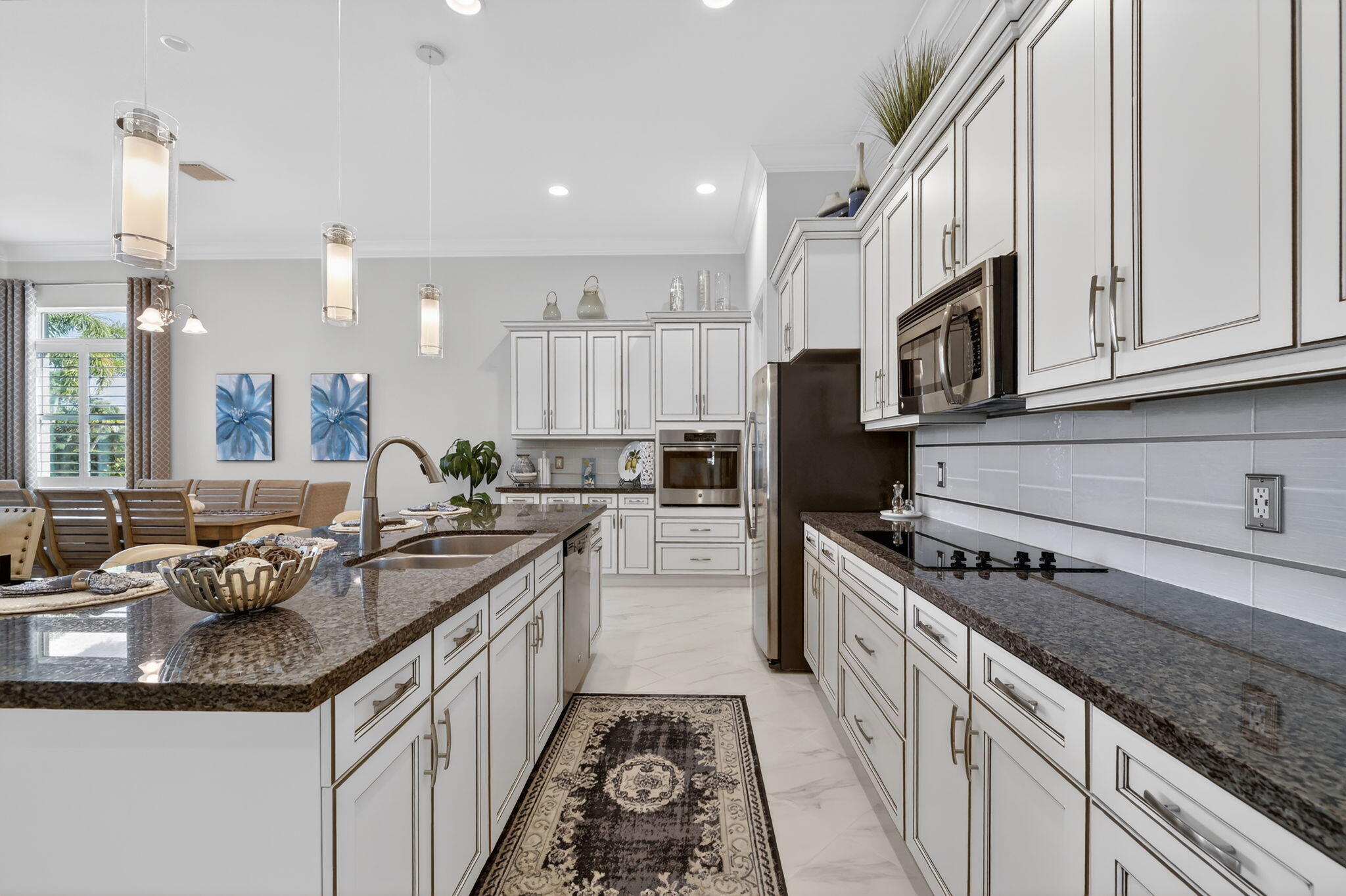 10619 Southwest Capraia Way Port St. Lucie, FL 34986 - Photo 10 of 90 a kitchen with stainless steel appliances granite countertop a sink stove and cabinets