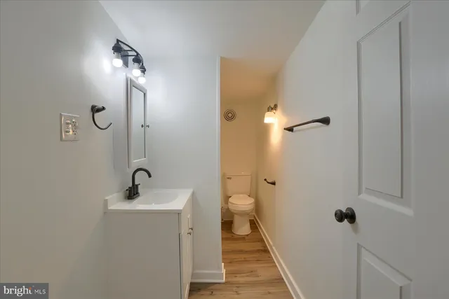 a bathroom with a sink and mirror with toilet