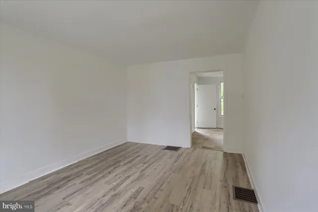 a view of a room with wooden floor and white walls