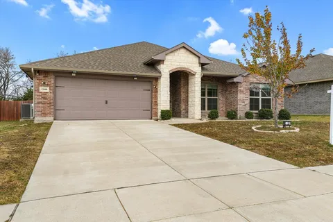 a front view of a house with a yard and a garage