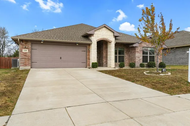 a front view of a house with a yard and a garage