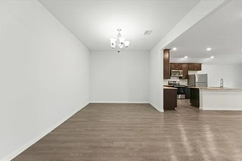 a view of kitchen with granite countertop cabinets and refrigerator