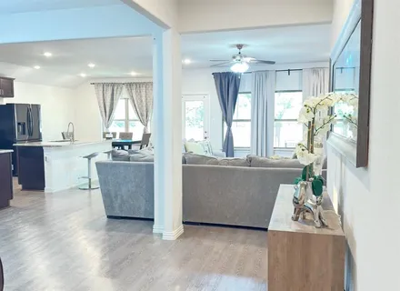 a living room with furniture and kitchen view