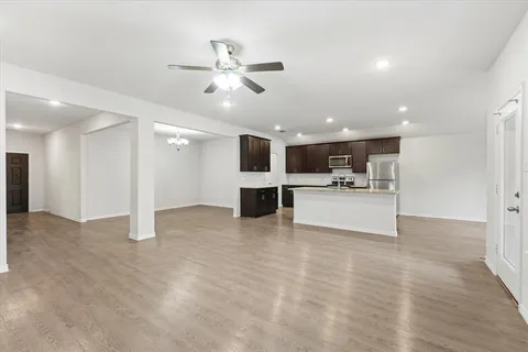 a kitchen with stainless steel appliances granite countertop a stove and a wooden floors