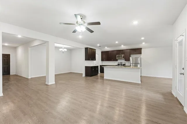 a kitchen with stainless steel appliances granite countertop a stove and a wooden floors
