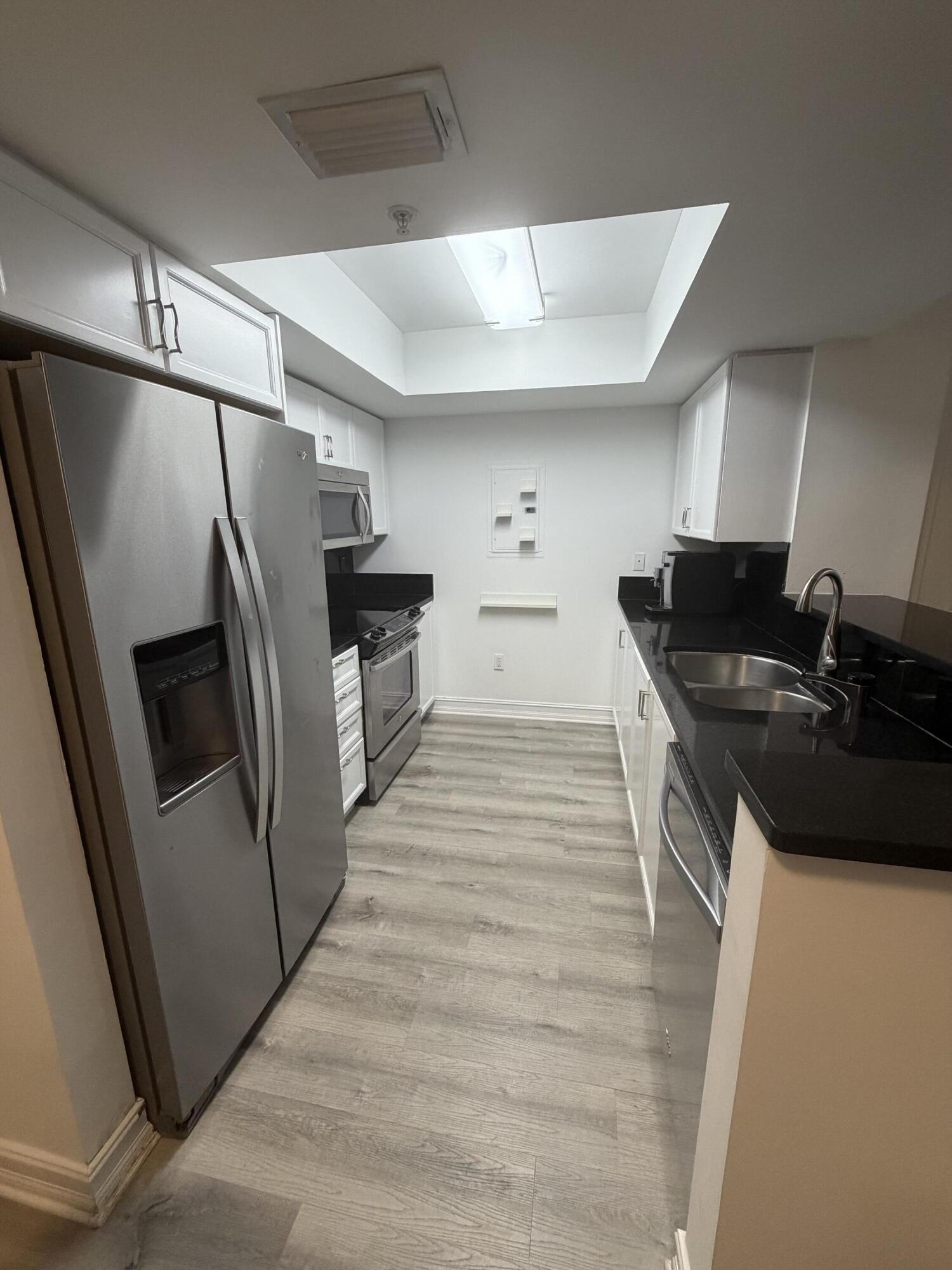 99 Southeast Mizner Boulevard, Unit 648 Boca Raton, FL 33432 - Photo 3 of 19 a kitchen with granite countertop a refrigerator and a sink
