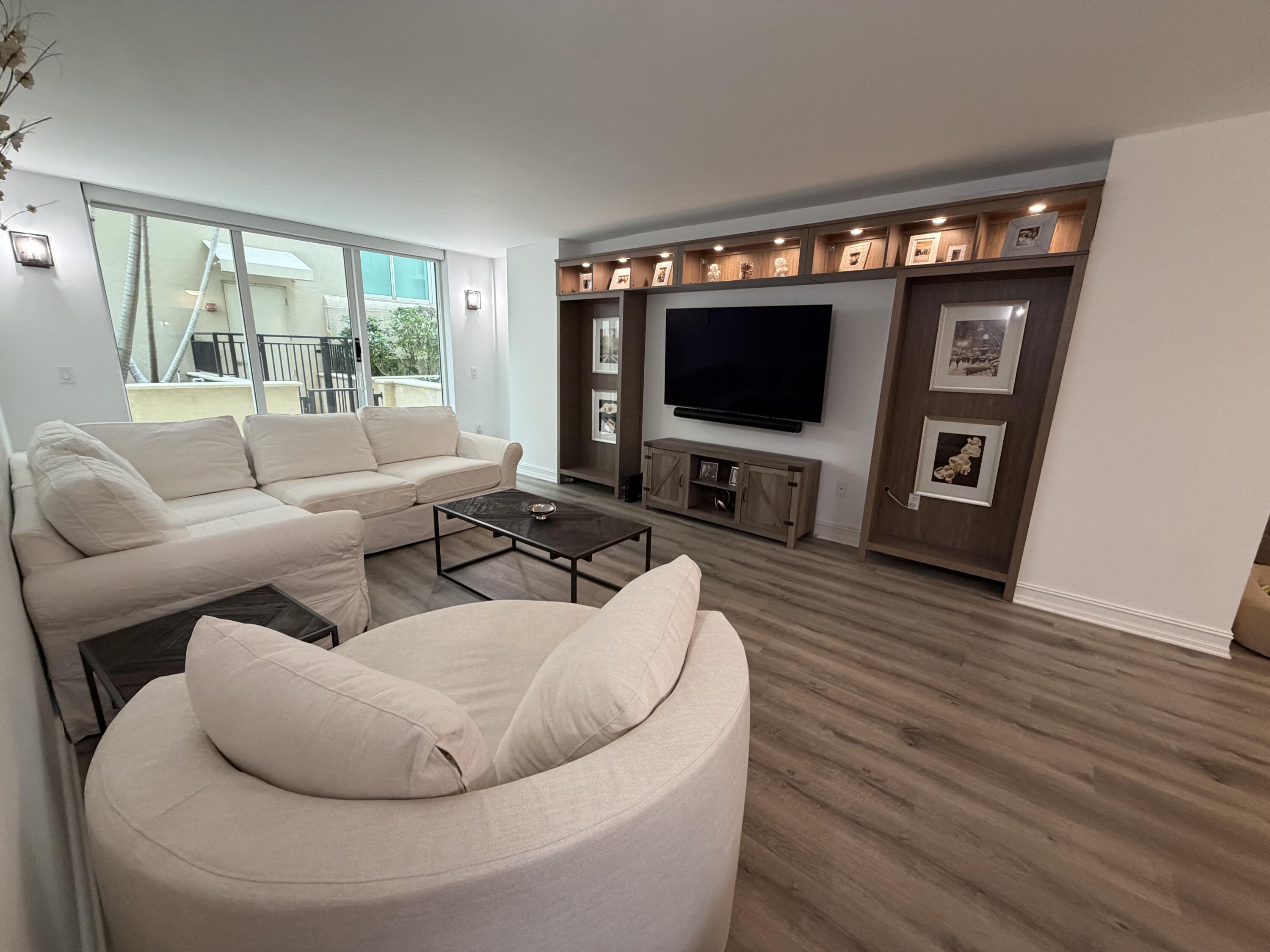 99 Southeast Mizner Boulevard, Unit 648 Boca Raton, FL 33432 - Photo 6 of 19 a living room with furniture and a flat screen tv