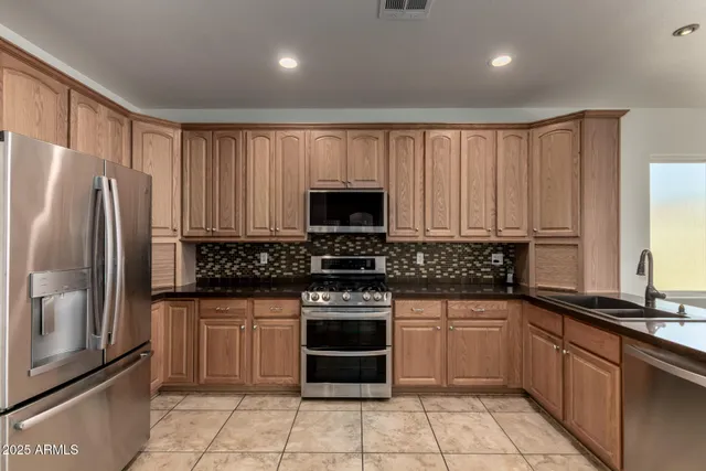 a kitchen with granite countertop a stove sink and refrigerator