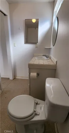 a bathroom with a toilet a sink and mirror