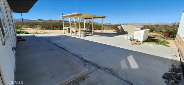 a view of a patio with a table and chairs under an umbrella