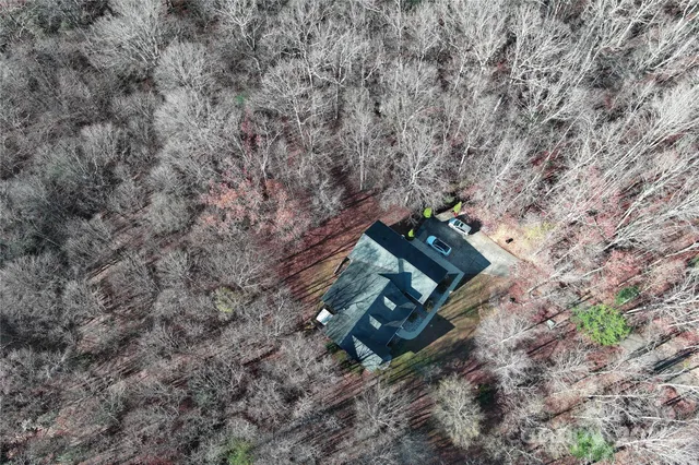 a view of yellow house with large trees