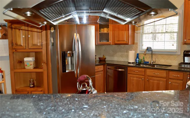 a kitchen with stainless steel appliances granite countertop a refrigerator and a sink