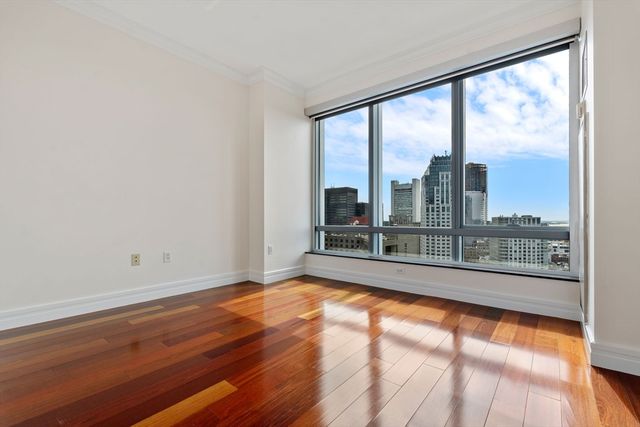 a view of empty room with wooden floor and floor to ceiling window