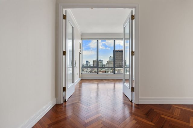 a view of a hallway with wooden floor and glass door