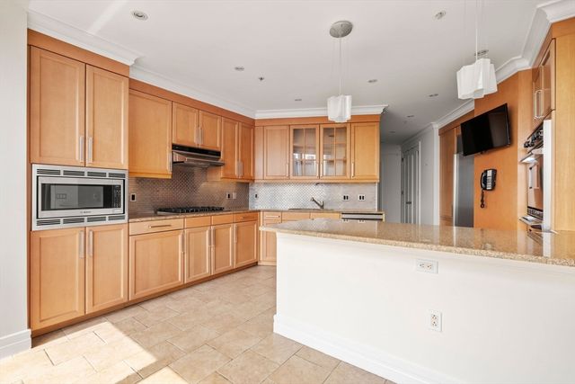 a large kitchen with stainless steel appliances kitchen island granite countertop a sink and cabinets