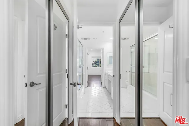 a view of a hallway with wooden floor and cabinet