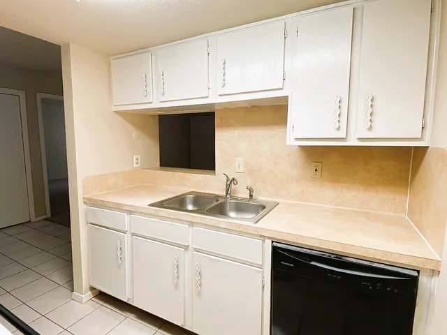 a kitchen with granite countertop white cabinets and a sink