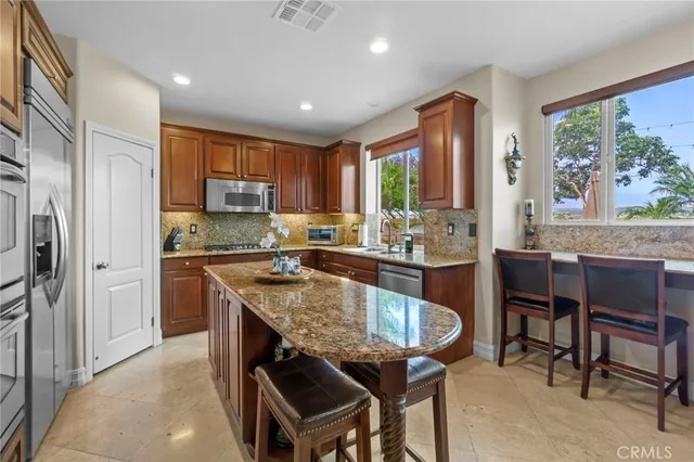a kitchen with a table chairs sink refrigerator and cabinets