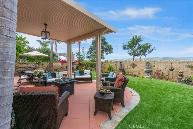 a view of a patio with couches potted plants and a big yard
