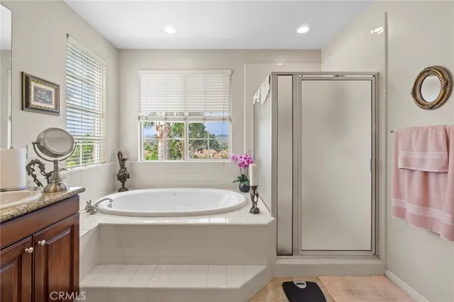 a spacious bathroom with a tub sink and mirror