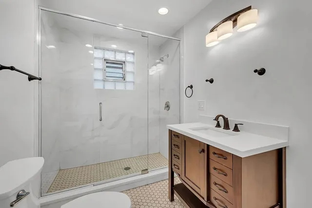 a bathroom with a sink a toilet and shower