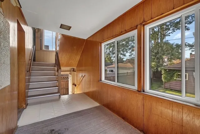 a view of a hallway with stairs and a window