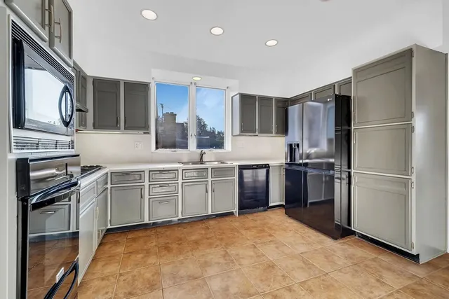 a kitchen with stainless steel appliances a refrigerator sink and microwave