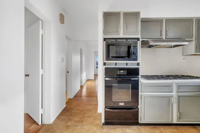 a kitchen with kitchen island granite countertop a stove and a refrigerator