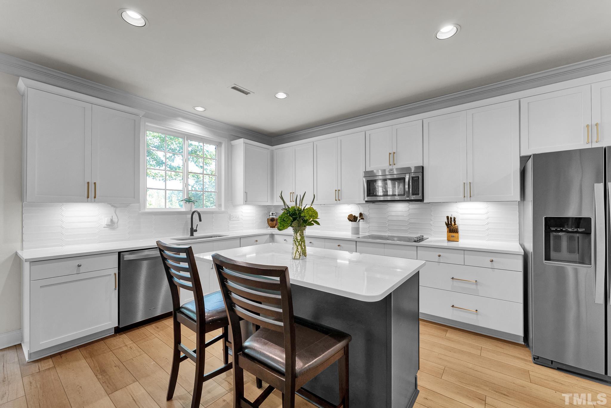 161 Ryder Cup Circle Raleigh, NC 27603 - Photo 3 of 31 a kitchen with a table chairs refrigerator and cabinets