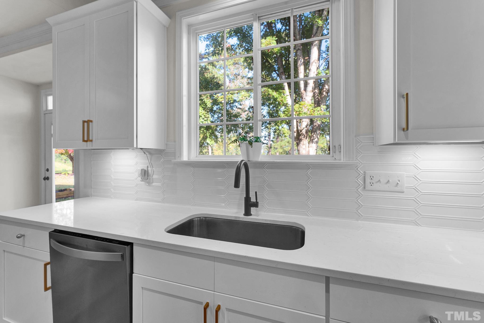 161 Ryder Cup Circle Raleigh, NC 27603 - Photo 5 of 31 a kitchen with stainless steel appliances white cabinets a sink and a window