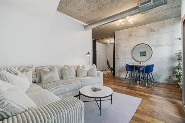 a living room with furniture a rug and wall paintings